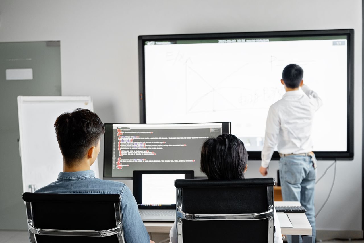 Mastering the First Impression: Your intriguing post title goes here Team conducting a business presentation with technology in a modern office setting.